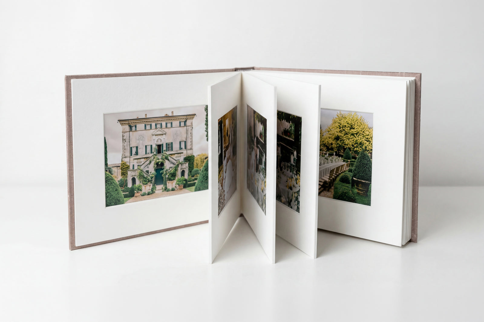 A matted book standing open, each thick archival mat holding a single photograph