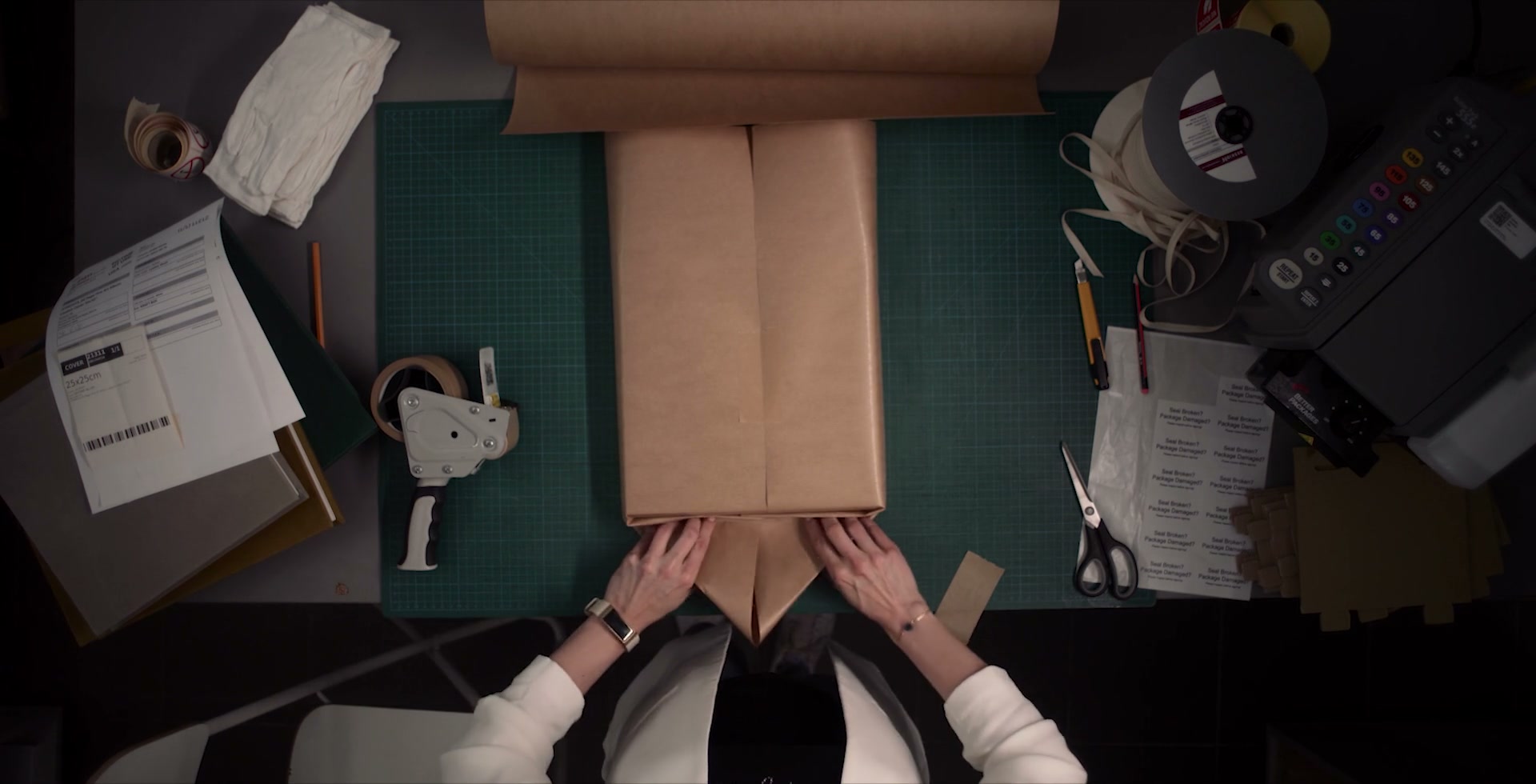 Hands folding paper around an album