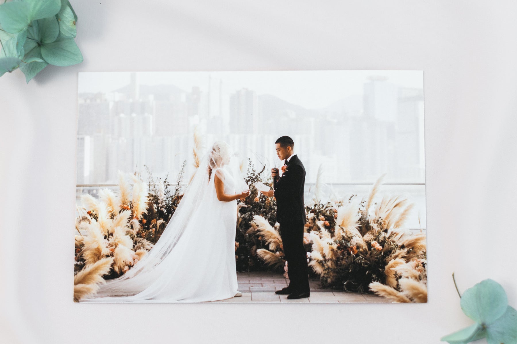 Two photographic prints from a family meadow session, laid on pale wood